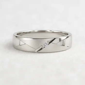 Men's white gold wedding band with a single round diamond and engraved geometric design, displayed on white background