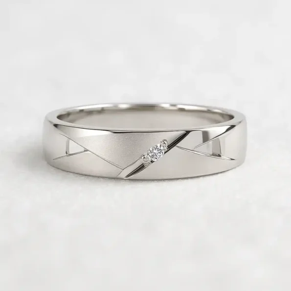 Men's white gold wedding band with a single round diamond and engraved geometric design, displayed on white background