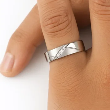Close-up of men's white gold diamond wedding band worn on finger, featuring a diagonal trio of round diamonds and brushed detailing