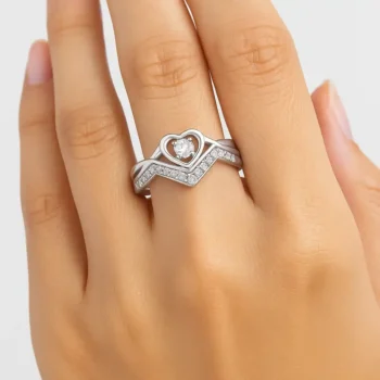 Heart diamond engagement ring with V-band displayed on hand for scale and fit