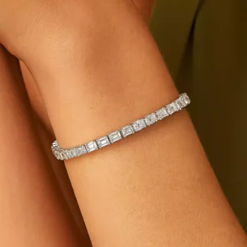 Stylish emerald and oval cut diamond tennis bracelet worn on wrist, featuring lab-grown diamonds in white gold