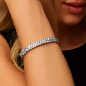 White gold round diamond bangle bracelet on woman’s wrist - elegant luxury jewelry style
