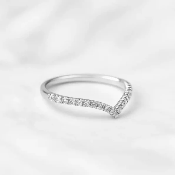 White gold V-shaped diamond band ring with pave setting on white background