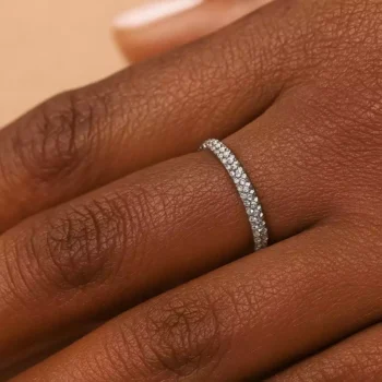 White gold diamond eternity band ring on dark skin hand for women