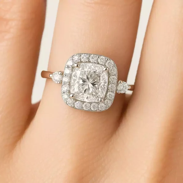 Cushion cut lab diamond halo ring with round side stones on woman's hand – elegant bridal jewelry