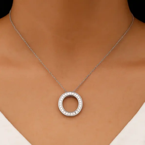 Woman wearing elegant round diamond circle pendant necklace in white gold