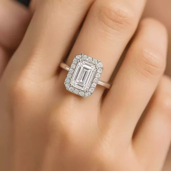 Emerald cut halo diamond engagement ring on woman's hand – lab-created diamond in white gold setting