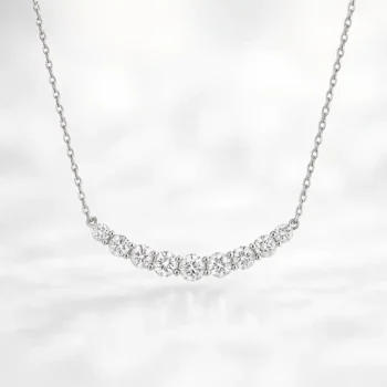 Front view of white gold journey-style necklace featuring graduated round lab-grown diamonds in a curved bar setting