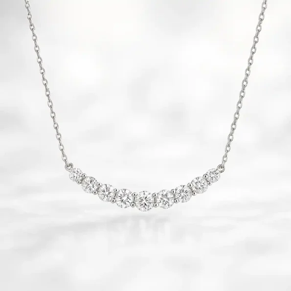 Front view of white gold journey-style necklace featuring graduated round lab-grown diamonds in a curved bar setting