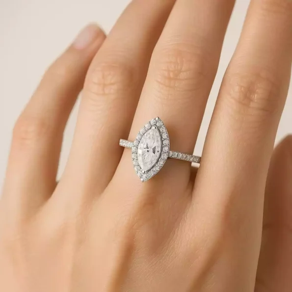 Marquise cut halo diamond ring worn on hand in elegant white gold setting with pave band