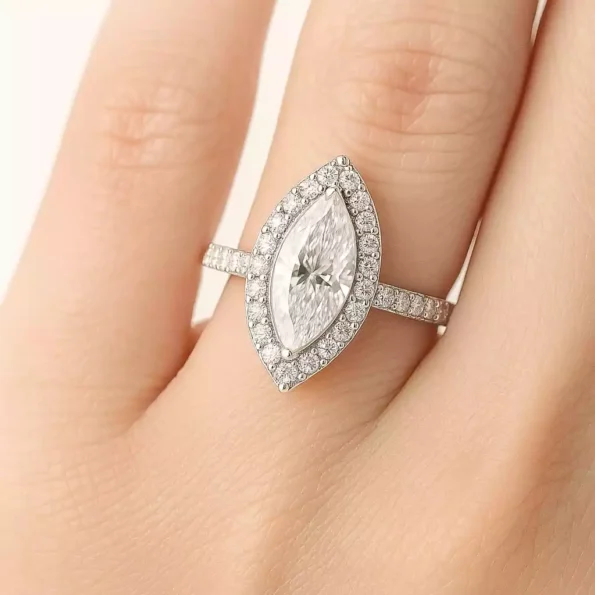 Marquise cut halo diamond ring worn on hand in elegant white gold setting with pave band
