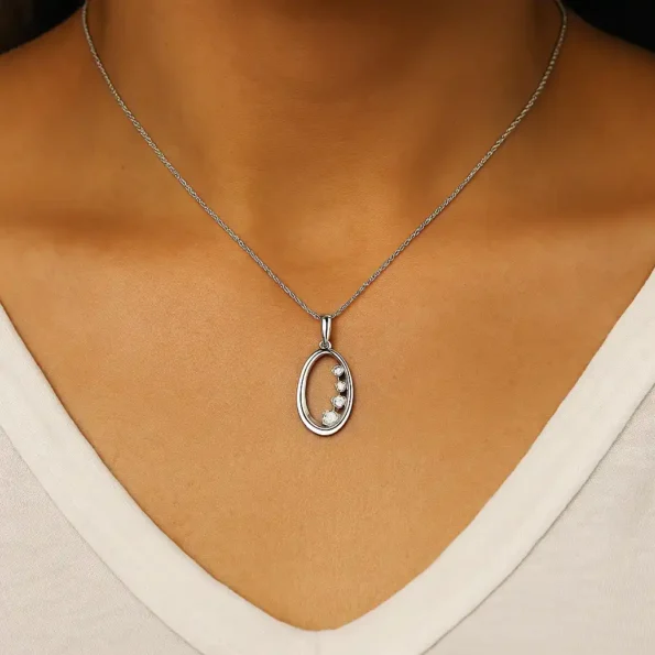 Model wearing oval journey pendant necklace with 4 graduated lab-created diamonds in white gold chain