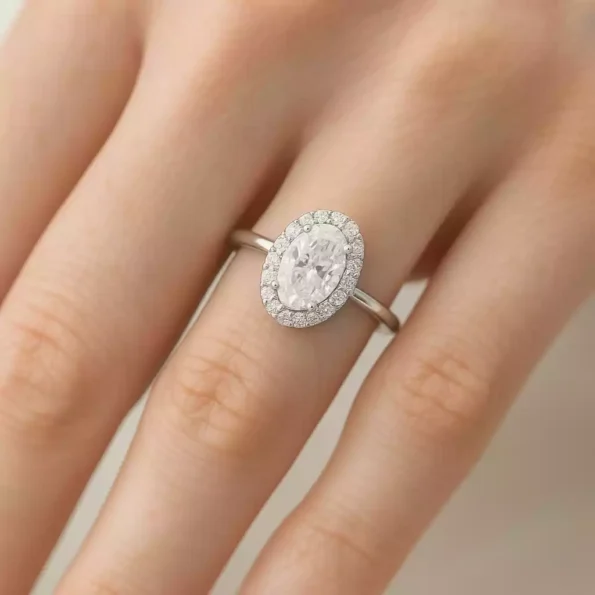 Oval diamond halo engagement ring worn on hand - lab diamond in 18K white gold setting