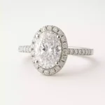 Oval cut lab-grown diamond halo engagement ring in 18K white gold with pave band – front view