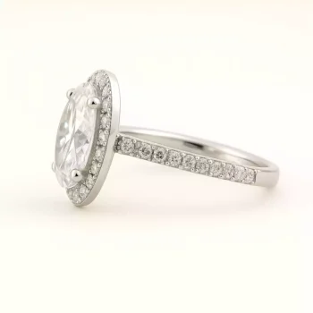 Side profile of oval cut diamond halo ring with 18K white gold and micro pave diamonds on shank