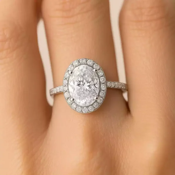 Oval cut lab diamond engagement ring with halo setting on woman's finger – elegant white gold ring