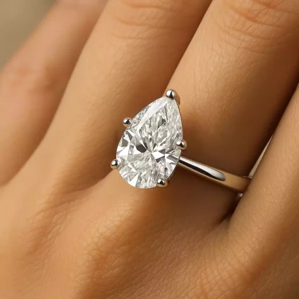 Pear cut lab diamond engagement ring on woman’s hand – classic white gold solitaire look