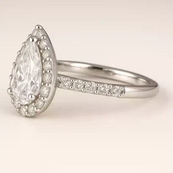 Side profile of pear cut halo lab diamond ring with pavé band in white gold