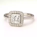 Princess cut lab diamond halo engagement ring in white gold with round diamond accents.