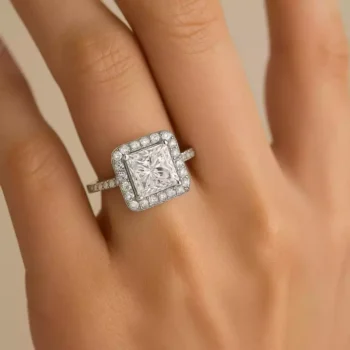 Princess cut diamond halo ring in white gold shown on hand for scale and elegance