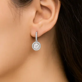 Model wearing round halo lab-grown diamond drop earrings with prong diamond huggie setting