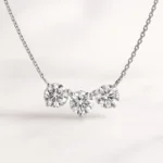 Three stone round cut lab-grown diamond necklace in white gold setting on delicate chain - front view