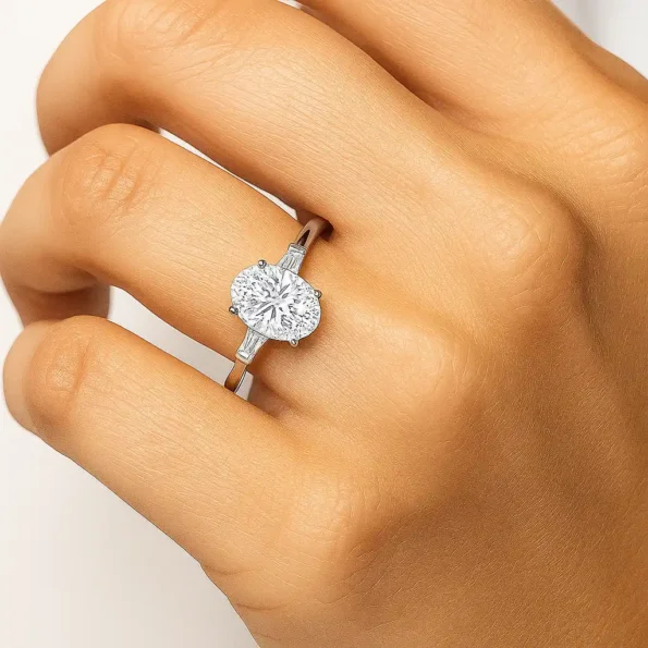 Elegant oval cut lab grown diamond ring with baguette side diamonds shown on model hand