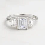 Emerald cut three-stone lab-grown diamond engagement ring in white gold with step-cut side stones