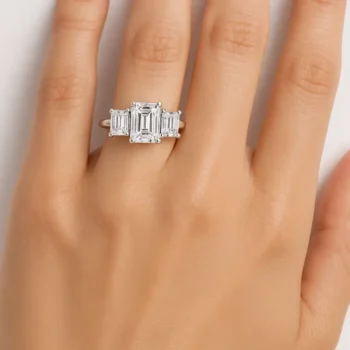 Emerald cut three-stone diamond ring on hand – lab-grown diamonds set in minimalist white gold band