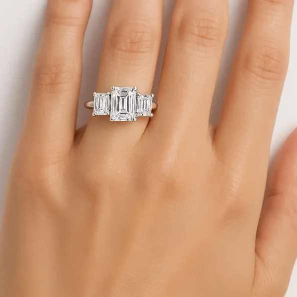 Emerald cut three-stone diamond ring on hand – lab-grown diamonds set in minimalist white gold band