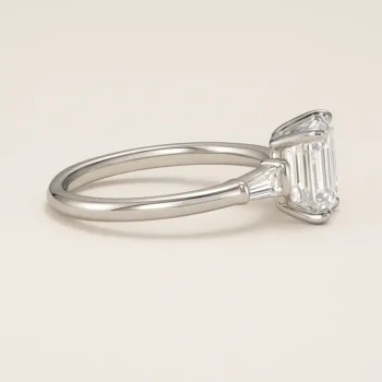 Side profile of emerald cut diamond engagement ring with baguette side diamonds in a white gold setting