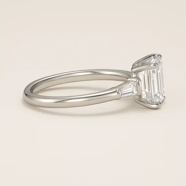 Side profile of emerald cut diamond engagement ring with baguette side diamonds in a white gold setting