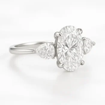 Elegant three-stone oval diamond ring with pear side stones set in white gold – angled side view