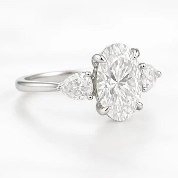 Elegant three-stone oval diamond ring with pear side stones set in white gold – angled side view