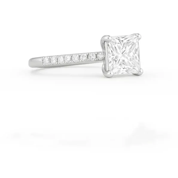 Side profile of princess cut diamond ring with four-prong setting and pavé diamonds on slim white gold band